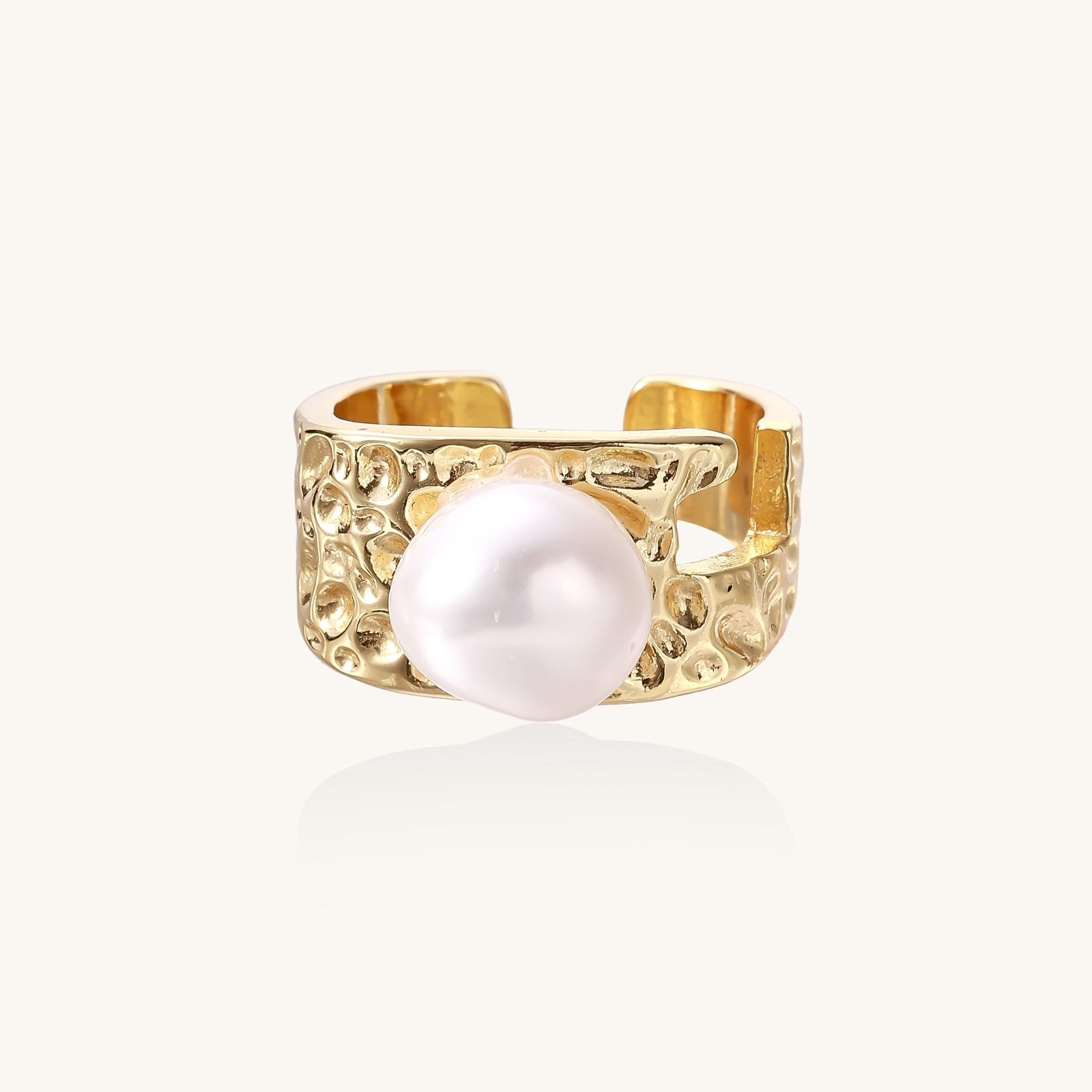 Wide textured gold-plated brass ring with round freshwater pearl centerpiece on neutral background