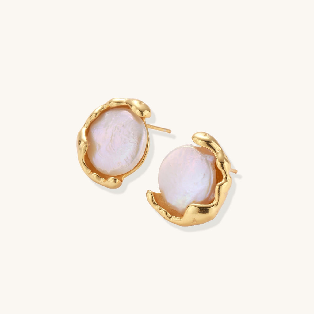 Gold-plated sterling silver stud earrings with organic claw settings cradling lustrous freshwater pearls on white background.