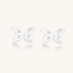 Delicate sterling silver butterfly stud earrings with intricate wing details on a neutral background.