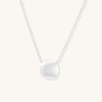 Minimalist sterling silver necklace with brushed square pendant on adjustable chain against white background.