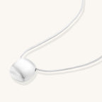 Minimalist sterling silver necklace with brushed square pendant on adjustable chain against white background.