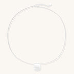 Minimalist sterling silver necklace with brushed square pendant on adjustable chain against white background.