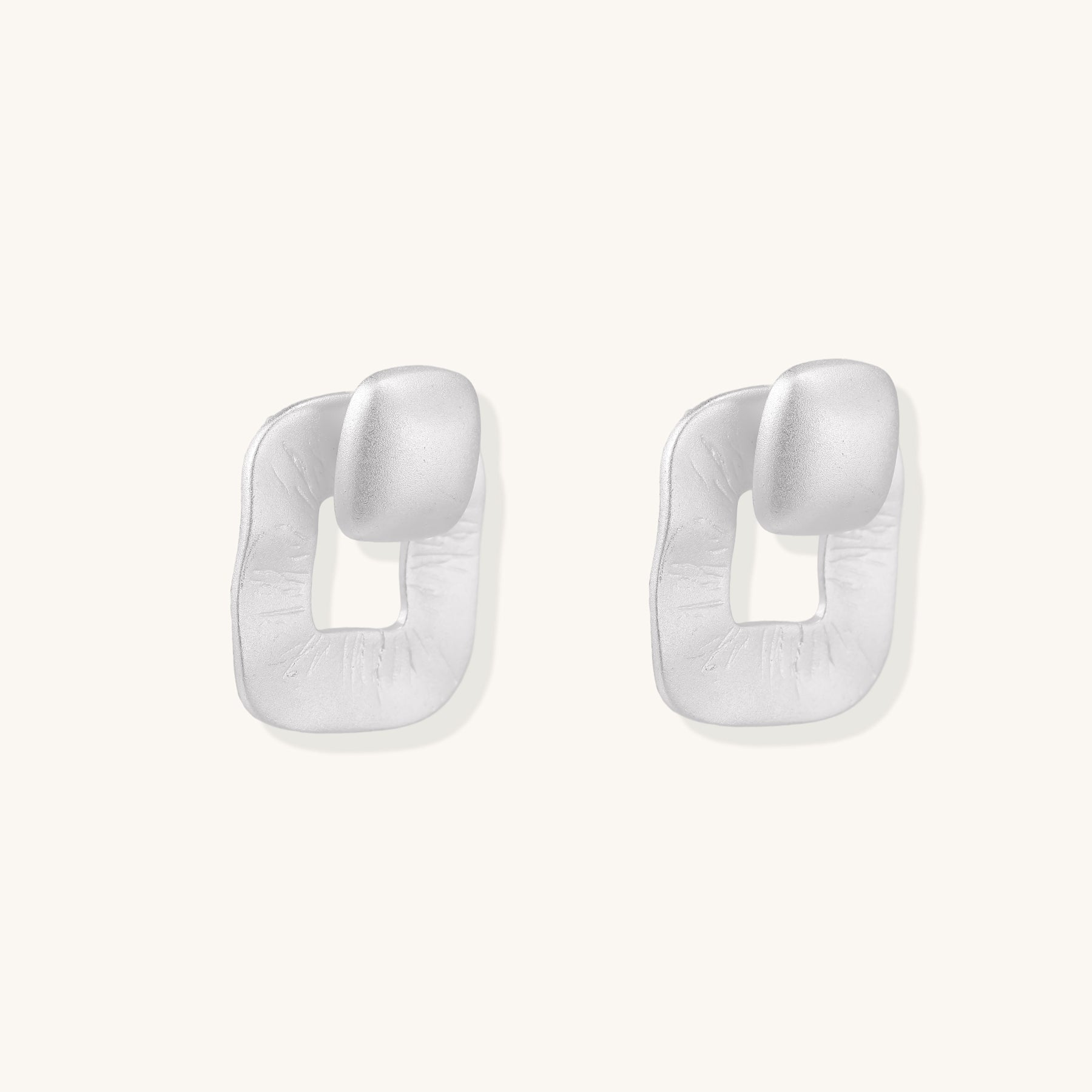 Geometric sterling silver square stud earrings with brushed texture and central square cutouts on white background.