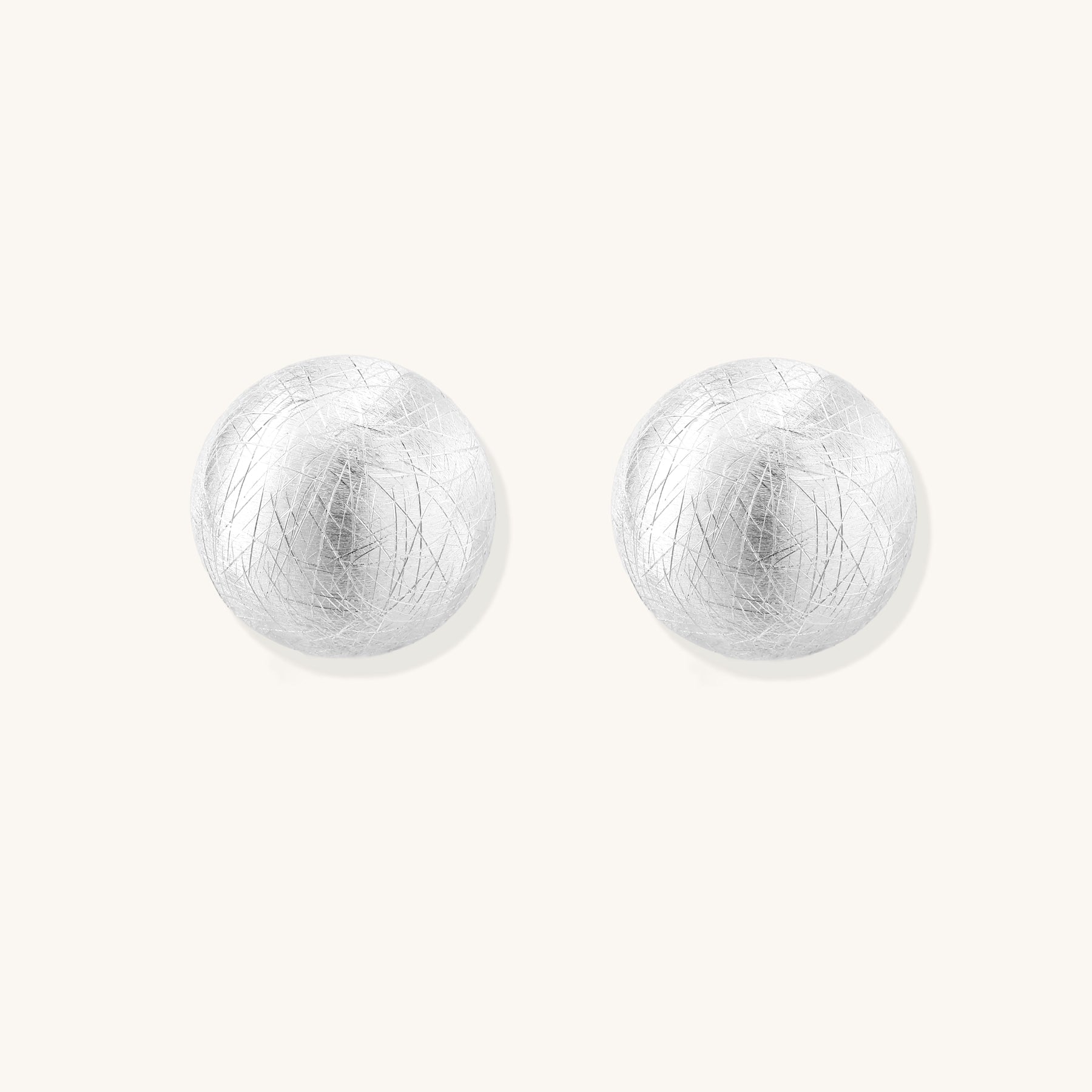 Brushed sterling silver dome-shaped stud earrings with textured surface and secure lever-back closure on white background.
