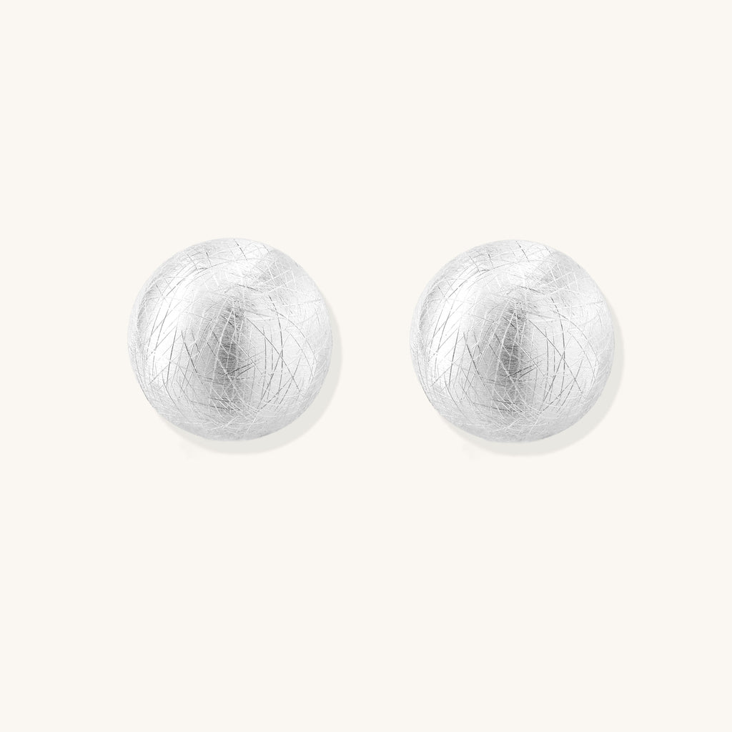Brushed sterling silver dome-shaped stud earrings with textured surface and secure lever-back closure on white background.
