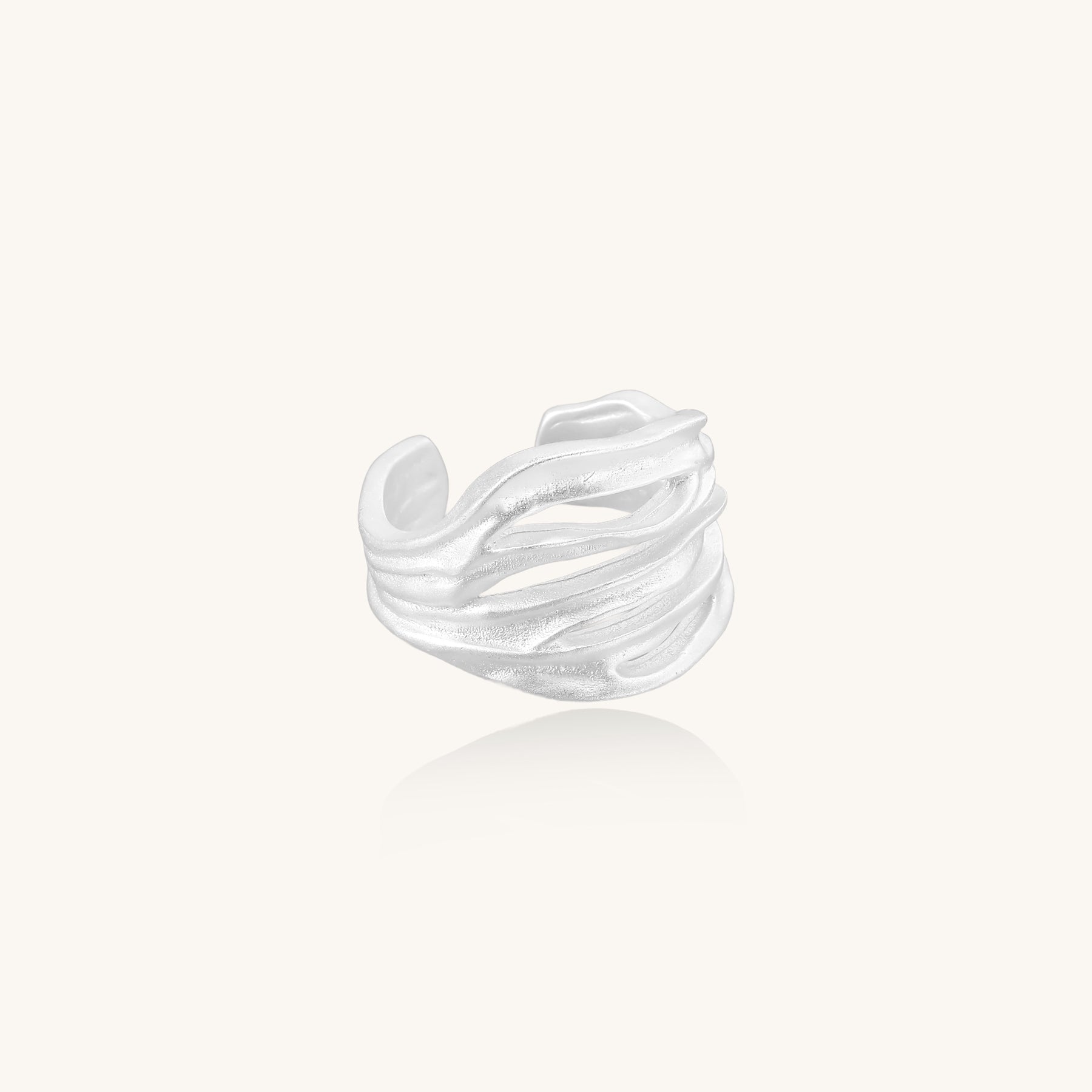 Wide sterling silver ring with flowing wave patterns and adjustable cuff design on white background.