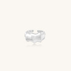 Chunky sterling silver ring with organic flowing design and brushed matte finish on neutral background