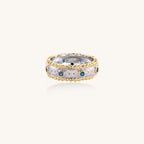Sterling silver ring with brushed center band, blue zirconia stones, and 24k gold-plated decorative borders.