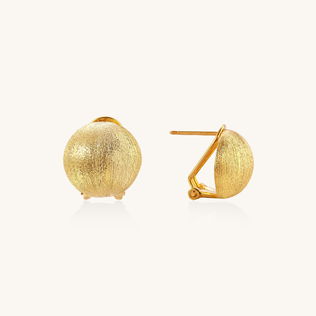 Close-up of textured gold-plated sterling silver dome clip-on earrings with brushed finish on white background.