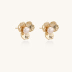 Gold-plated flower stud earrings with freshwater pearl centers on beige background, showing textured petal details.