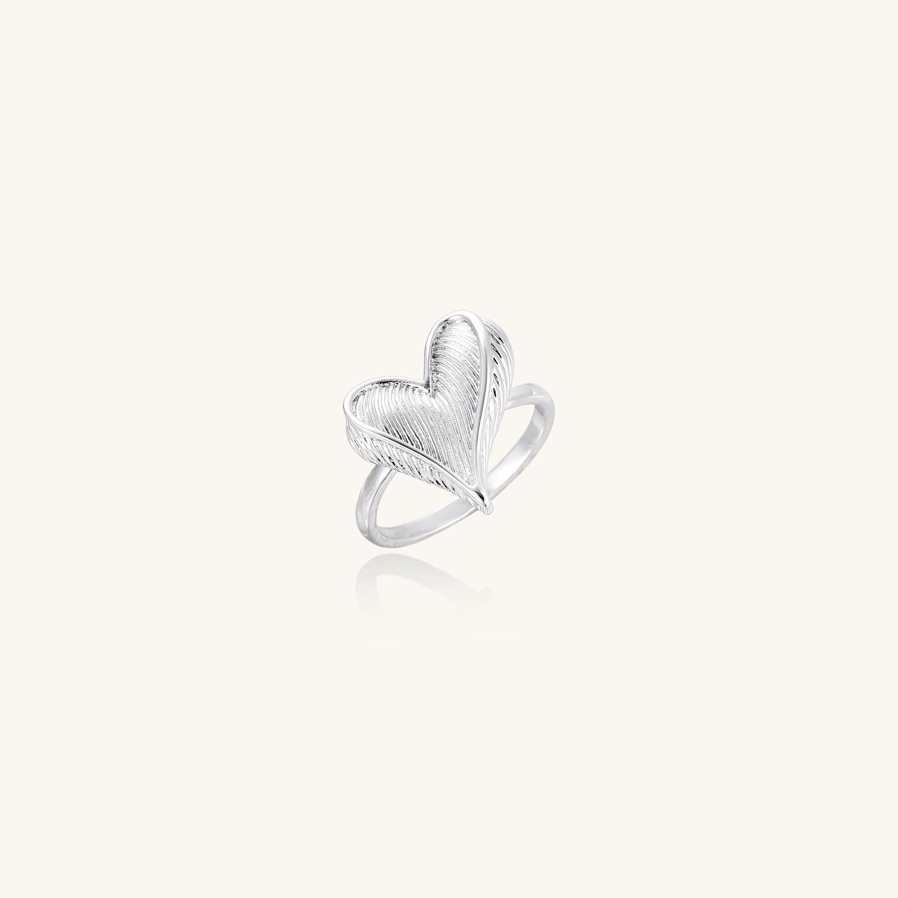 18K gold plated brass ring with intricate feather design forming a heart shape on white background.