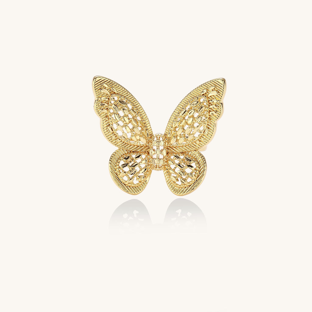 Adjustable gold-plated brass butterfly ring with intricate filigree cutout patterns and cubic zirconia accents on white background.
