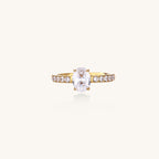 14K gold-plated ring with oval zirconia center stone and pavé band accent stones on white background.