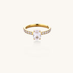 14K gold-plated ring with oval zirconia center stone and pavé band accent stones on white background.