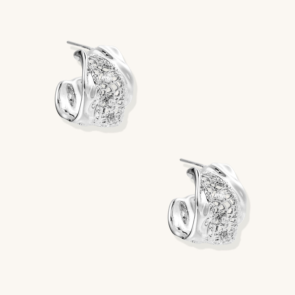 Small gold-plated brass hoop earrings with geometric lattice pattern and zirconia accents on white background.