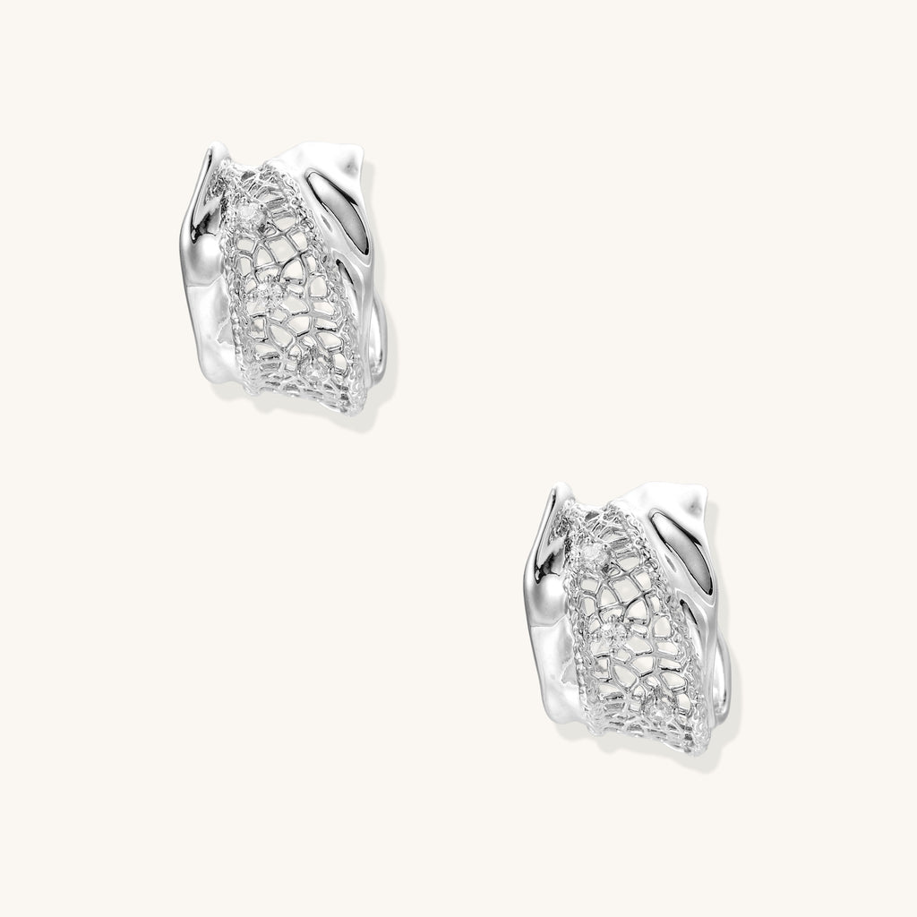 Small gold-plated brass hoop earrings with geometric lattice pattern and zirconia accents on white background.