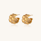 Small gold-plated hoop earrings with intricate braided texture pattern and post backs on white background.