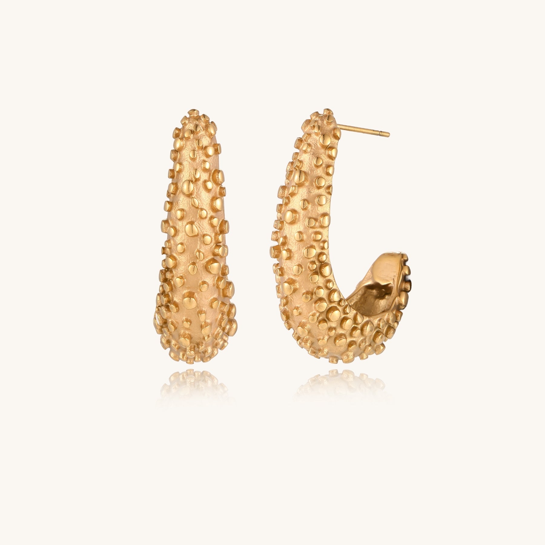 Pair of gold-plated hoop earrings with raised dotted texture surface shown from multiple angles on white background.
