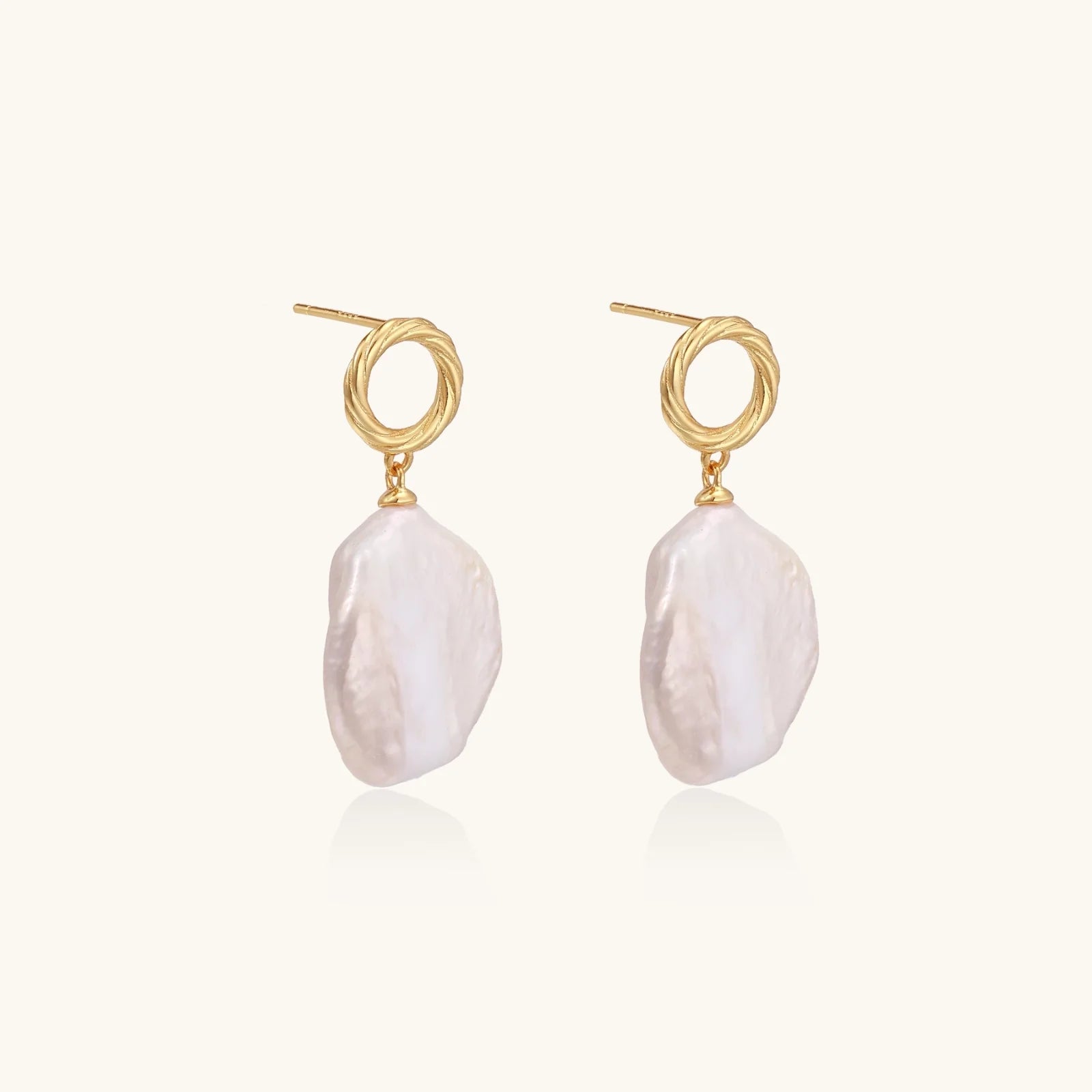 18K gold vermeil twisted circle studs with organic white baroque pearl drops on cream background