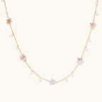 Gold vermeil chain with iridescent star-shaped baroque pearls and small round freshwater pearl drops on cream background.